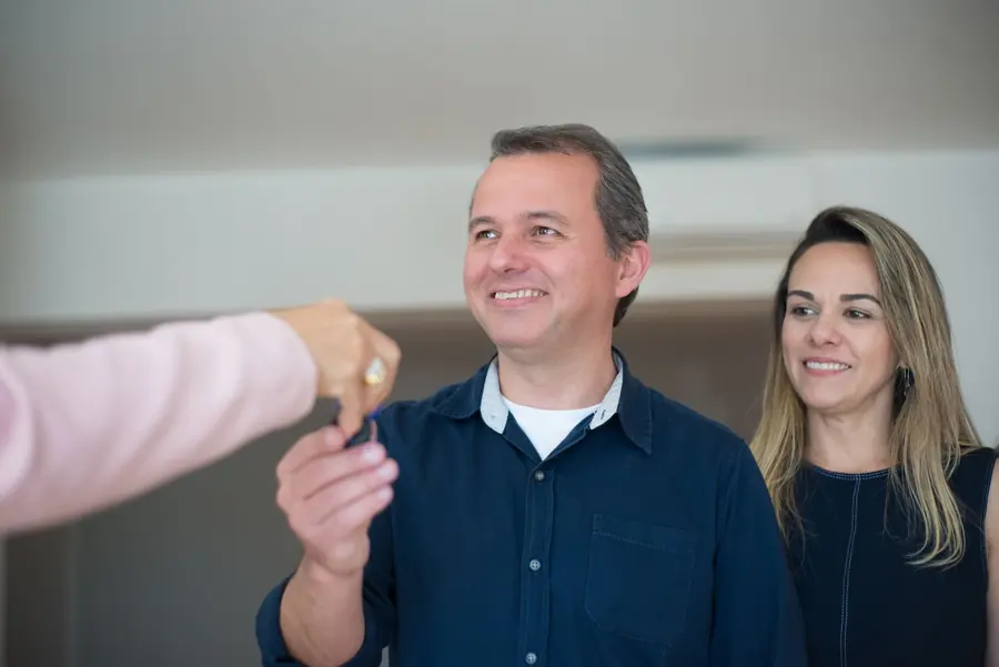 A couple being handed the keys to a new home.
