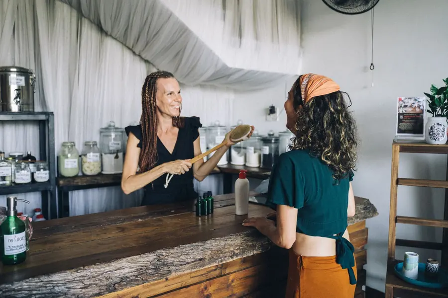 A small business owner standing behind the counter of their own shop.